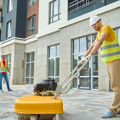 worker-cleaning-construction-site-and-two-men-near-2024-10-18-04-47-12-utc